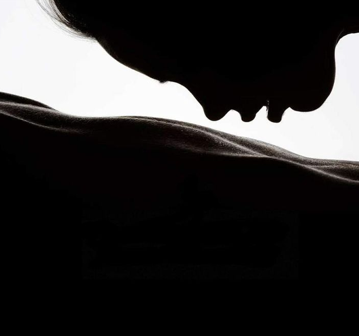 Silhouette of two lovers leaning close, lips almost touching — a tender moment symbolizing trust, vulnerability, and open communication.